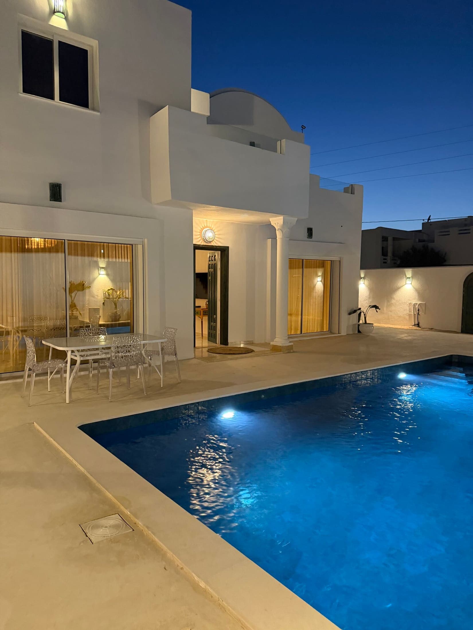 Casa Noah à la tombée du jour, la piscine éclairée devant la maison blanche