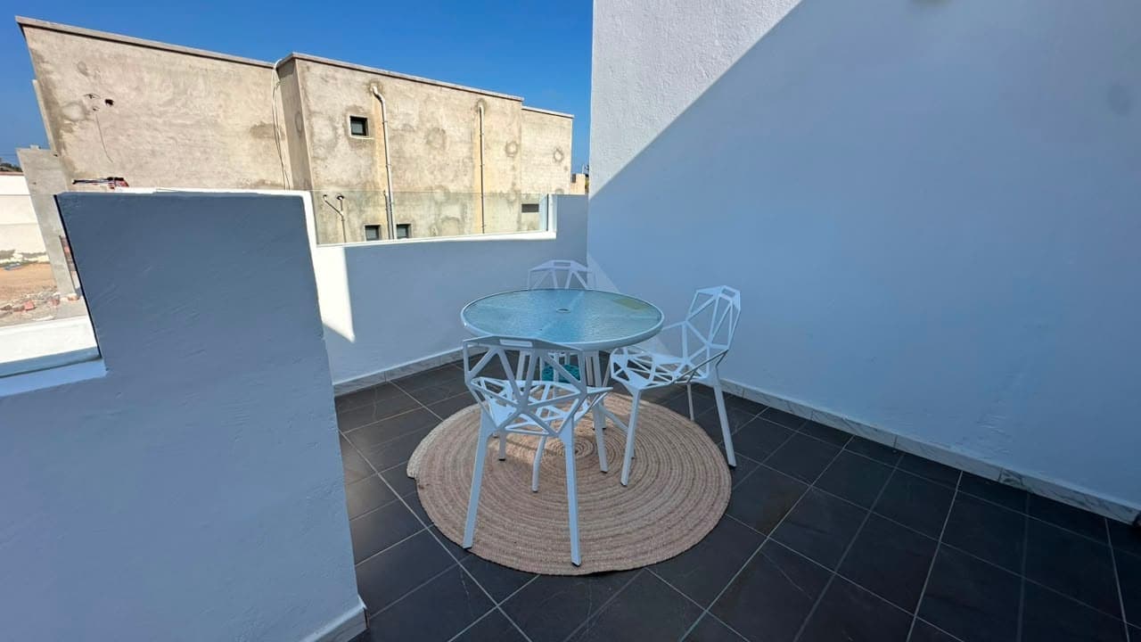 La terrasse sur le toit, une table ronde et quatre chaises